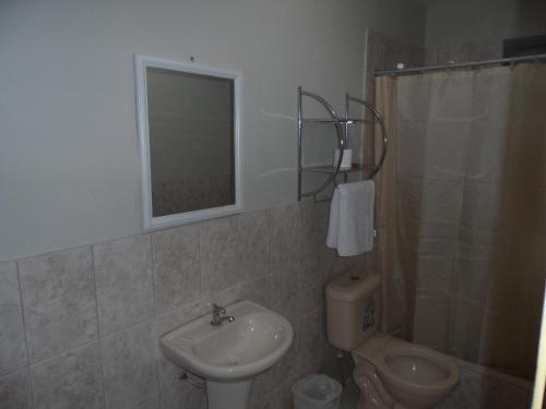 a bathroom with a sink and a toilet and a mirror at Antares Inn in Lima