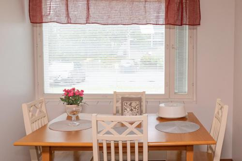 a dining room table with two chairs and a window at Apartment LA Invest in Rovaniemi