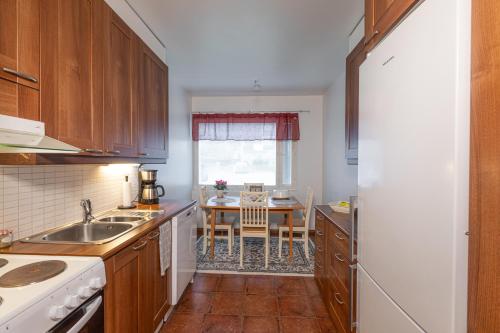 a kitchen with a sink and a table in it at Apartment LA Invest in Rovaniemi
