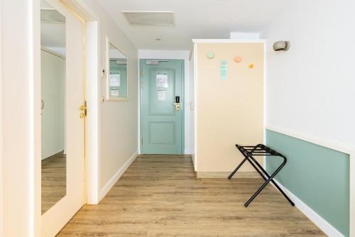 a hallway with a blue door and wooden floors at Garner Hotel Aschaffenburg Post by IHG in Aschaffenburg