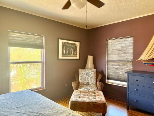 a bedroom with a bed and a chair and a window at Uptown Escape in Saint Augustine