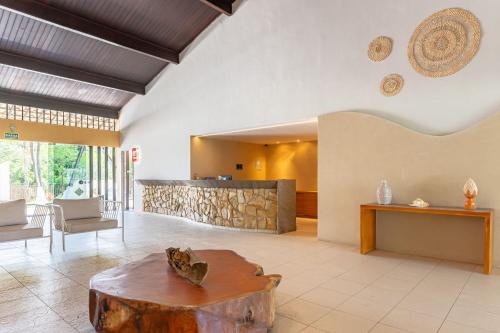 a living room with a tree stump coffee table at Flat Marupiara 220 - Muro Alto, Porto de Galinhas in Porto De Galinhas