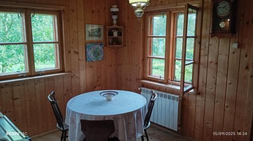 a table in the corner of a room with windows at Stajnia Okliny in Wiżajny