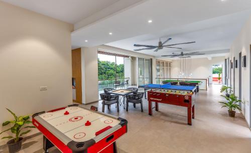 a living room with two ping pong tables at SaffronStays Grand Odyssy in Jambrung 