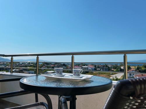 a table on a balcony with two cups on it at Doğanın Kalbindeki Eviniz-7 Kişi in Gemlik
