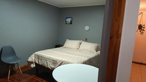 a small bedroom with a bed and a table at Lodge Atacama Hostal in Copiapó