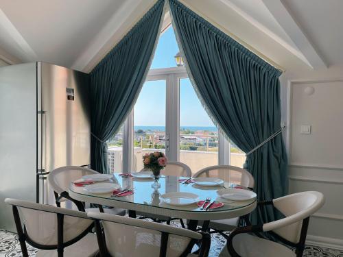 a dining room table with chairs and a large window at Doğanın Kalbindeki Eviniz-7 Kişi in Gemlik
