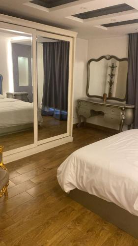 a bedroom with two beds and a mirror at Zm apartment shehab Vib in Cairo