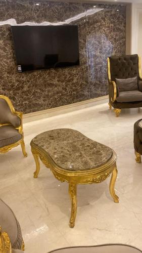 a gold coffee table in a living room with a tv at Zm apartment shehab Vib in Cairo