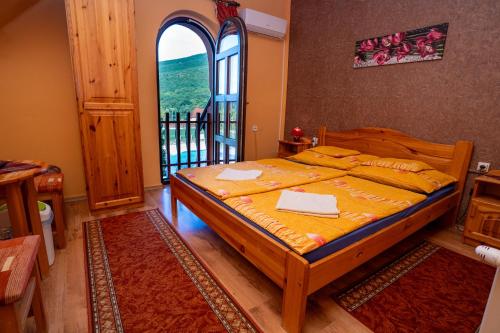 a bedroom with a bed and a large window at Hegyi Panzió in Szilvásvárad
