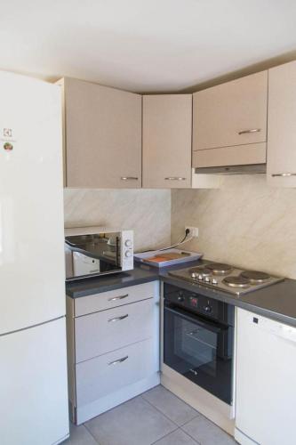 a kitchen with white cabinets and a stove top oven at Gite du mazel in Naussac