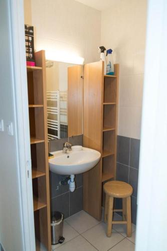 a small bathroom with a sink and a stool at Gite du mazel in Naussac