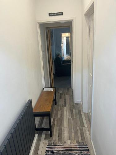 a hallway with a wooden bench in a room at George Guest House in Stoke on Trent