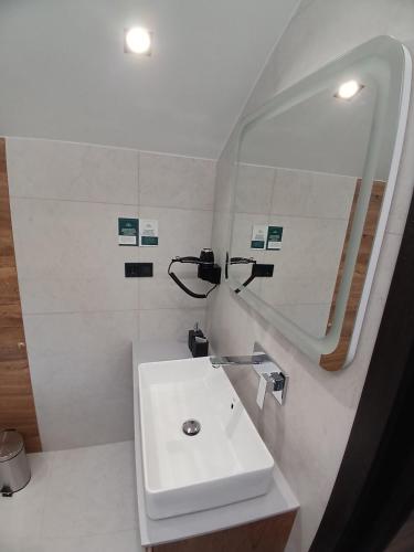 a white bathroom with a sink and a mirror at EcoBerghaus - Котеджне містечко in Bukovel