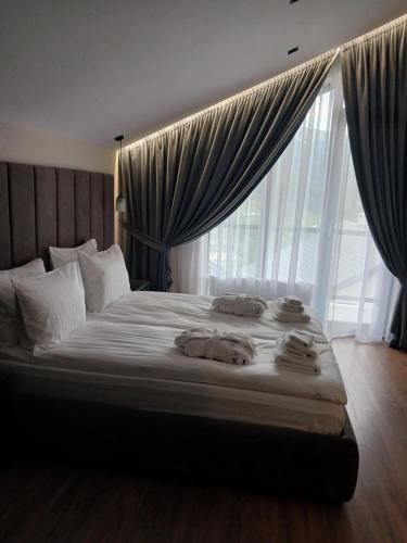 a bedroom with a large bed with towels on it at EcoBerghaus - Котеджне містечко in Bukovel