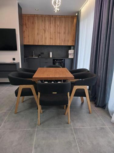 a dining room with a table and black chairs at EcoBerghaus - Котеджне містечко in Bukovel