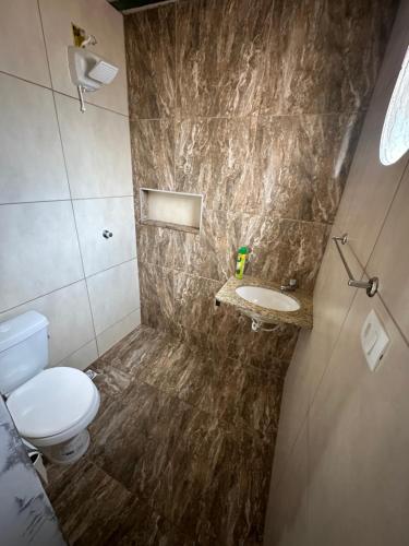 a bathroom with a toilet and a sink at Chalé Arco Iris in Esmeraldas