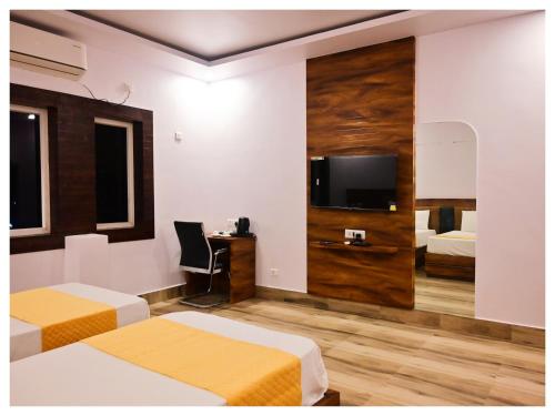a hotel room with two beds and a flat screen tv at अतिथि Atithi অথিতি Muzaffarpur Asthan Tample in Muzaffarpur