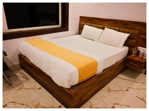 a bedroom with a large bed with a wooden frame at अतिथि Atithi অথিতি Muzaffarpur Asthan Tample in Muzaffarpur
