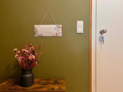 a vase of flowers on a table next to a door at Moderne Ferienwohnung mit Balkon & WLAN - zentral in Bad Wünnenberg
