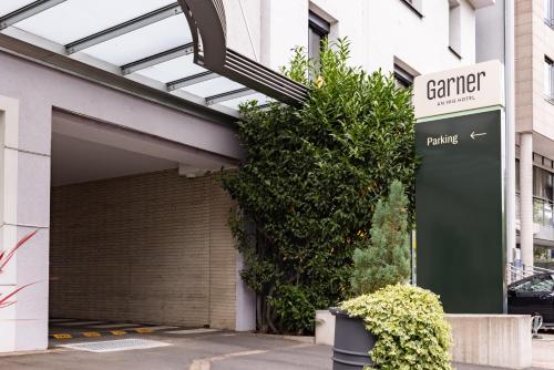 a garage with a parking sign in front of a building at Garner Hotel Aschaffenburg Post by IHG in Aschaffenburg