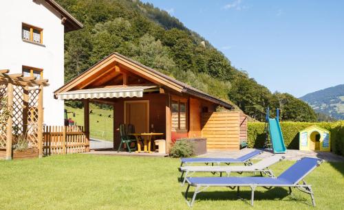 a small cabin with two picnic tables in the yard at Haus Gafrina in Schruns-Tschagguns