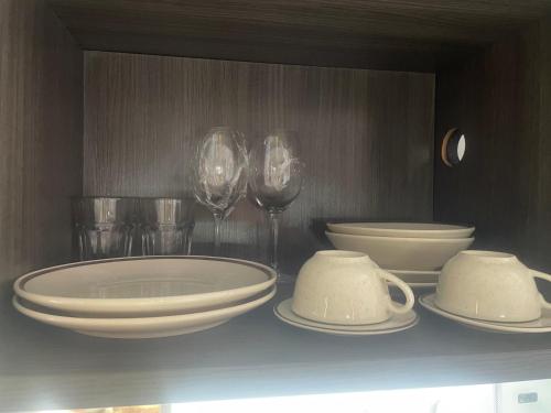 a table with plates and wine glasses on a shelf at Próx a praia in São Luís