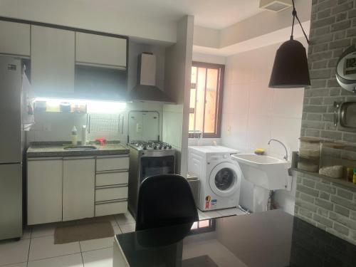 a kitchen with a stove and a washing machine at Próx a praia in São Luís