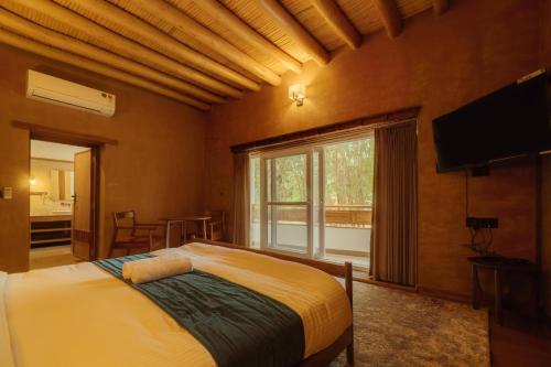 a bedroom with a bed and a large window at Hotel The Kaal in Leh
