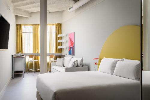 a hotel room with a bed and a chair at BYPILLOW Flamant in Barcelona