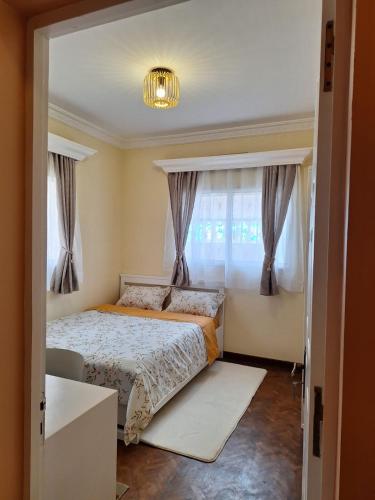 a bedroom with a bed and a window at Iravola Hebergement in Antananarivo