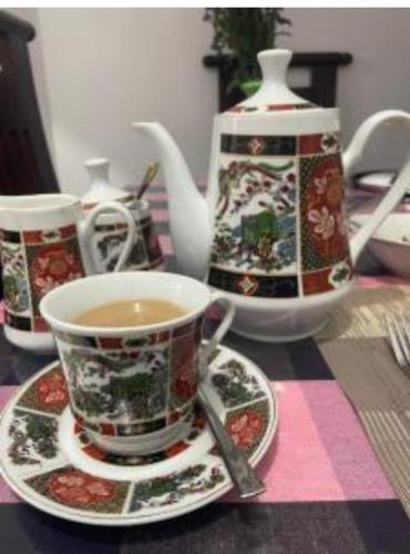 a table with cups and saucers and a tea pot at Mahesh Homestay in Galle