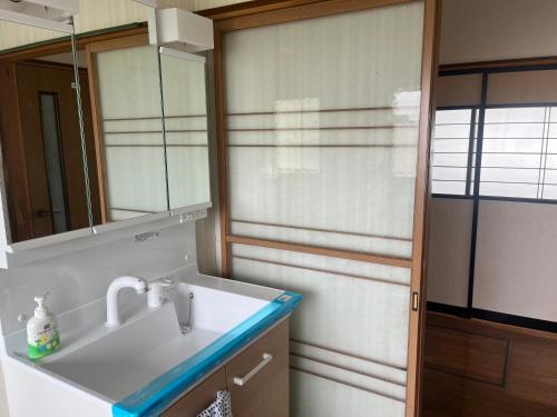 大仙市にある結ライ処 出羽紬yuraidokoro dewatsumugiの洗面台と鏡のあるバスルーム