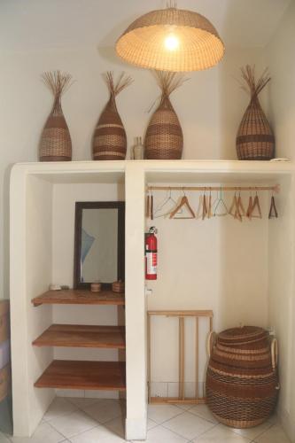 a room with a shelf with baskets and a mirror at Soufriere Guesthouse in Soufrière