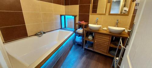a bathroom with two sinks and a bath tub at Les Lavandières de Fontaine in Fontaine-lès-Vervins