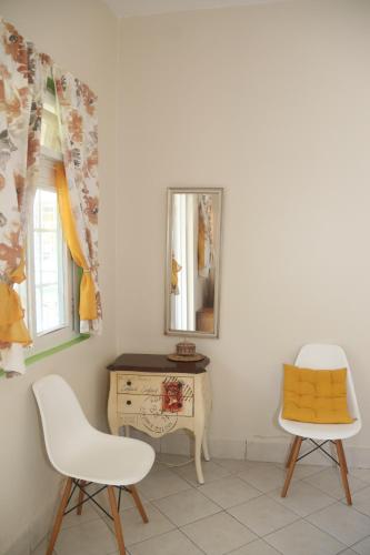 a room with two chairs and a table and a mirror at Soufriere Guesthouse in Soufrière