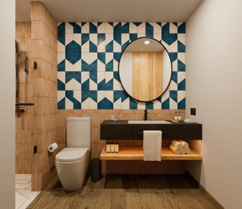 a bathroom with a toilet and a mirror at voco Ciudad de Mexico Reforma by IHG in Mexico City