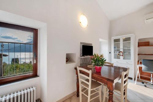 a dining room with a table and a window at Casa tua Alla Torre- Lago Di Iseo in Marone