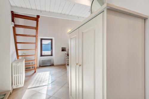 a hallway with white cabinets and a staircase in a house at Casa tua Alla Torre- Lago Di Iseo in Marone