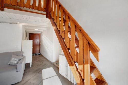 a wooden staircase in a living room with a couch at Casa tua Alla Torre- Lago Di Iseo in Marone
