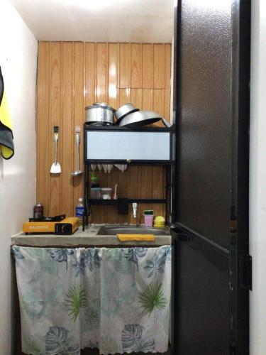 a kitchen with a refrigerator and a sink at Honu Homestay Siargao in Sampong