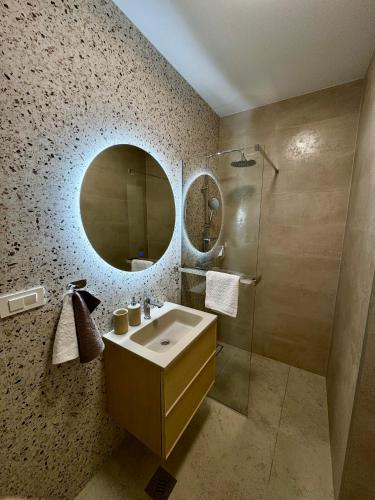 a bathroom with a sink and a mirror and a shower at Villa D Cube in Kremena
