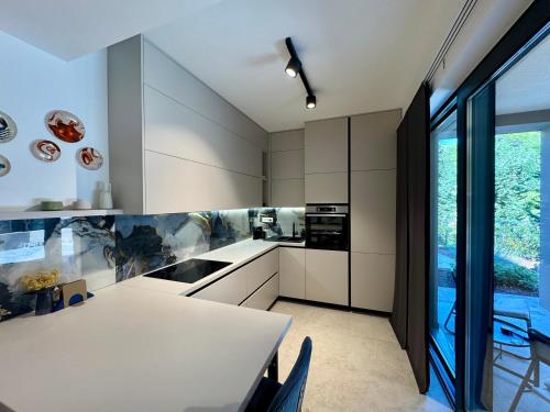 een keuken met witte kasten en een tafel met stoelen bij Villa D Cube in Kremena