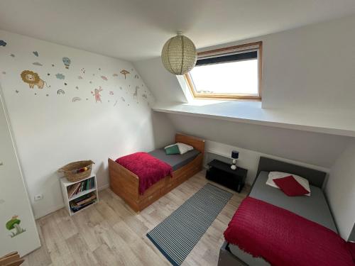Un dormitorio pequeño con dos camas y una ventana. en villa Maopi, en Wimereux