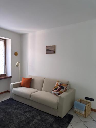 a white living room with a couch and a window at The Lake Stop in Marone
