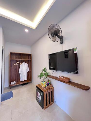 a living room with a flat screen tv on a wall at Lá Nhỏ Homestay Mộc Châu in Mộc Châu