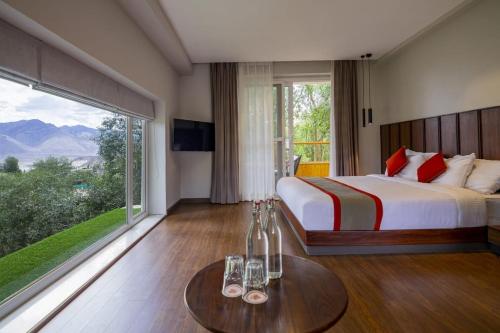 a bedroom with a large bed and a large window at Hotel The Kaal in Leh