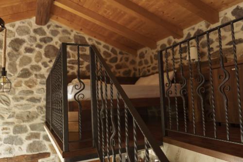 a staircase in a room with a bed and a stone wall at Kompleks Etno Luks in Crvulevo