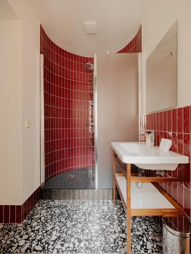 a bathroom with a sink and a shower at Edgar Suites - Lemercier in Paris