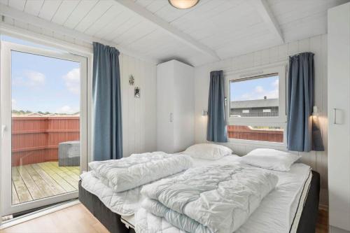 a bedroom with two beds and a large window at LN2020-Hjorring-Fjorden-2 in Lønstrup